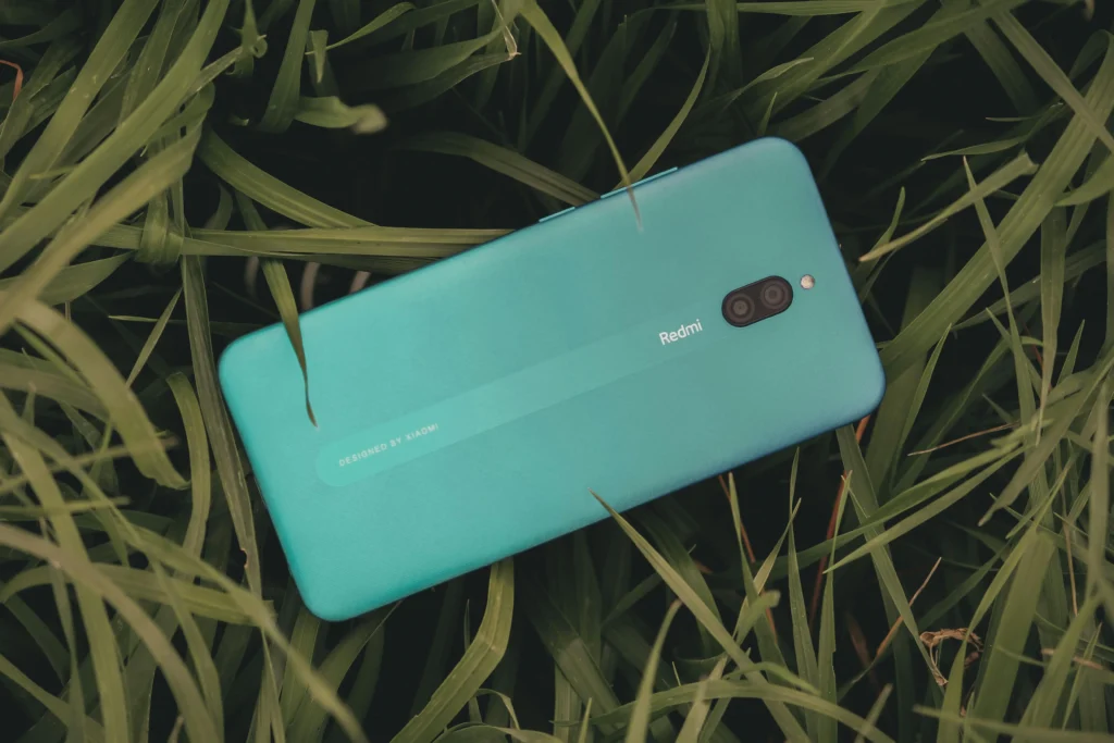 a Redmi cell phone on grass